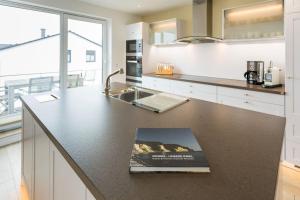 a kitchen with a book on a counter at Villa am Kreidebruch - Ostseeweitblick in Sassnitz +12 photos