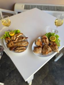 two plates of food on a table with glasses of wine at Hotel Yjet in Pogradec +13 photos