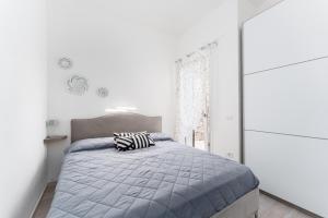 a bedroom with a bed with a gray comforter at Casa della Luna con piscina in Budoni +24 photos