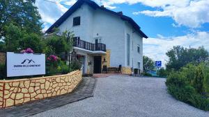 a white house with a sign in front of it at Zagora Hills Premium Apartman in Krapina
