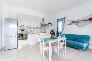 a kitchen with a table and a blue couch at Casa della Luna con piscina in Budoni