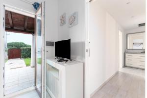 a living room with a tv on a white wall at Casa della Luna con piscina in Budoni
