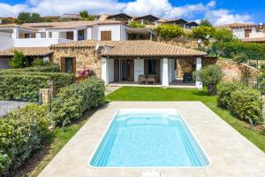a villa with a swimming pool in front of a house at Casa della Luna con piscina in Budoni