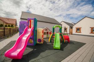 a playground with three slides in front of a house at Domki Przewłoka in Przewłoka