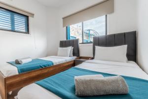 two beds in a room with a window at Beachside Hideaway Apartment, 200m to the Havana Beach in Pyla