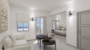 a white living room with a bed and a table at Terracotta Sunset Suites in Oia
