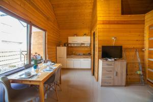 a dining room with a table and a kitchen at Domki Przewłoka in Przewłoka
