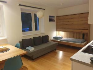 a living room with a couch and a bed at Ski & Sky Apartment in Hinterstoder