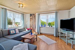 a living room with a couch and a flat screen tv at Ferienhof Knudsen in Pellworm