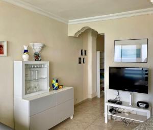 a living room with a television and a white entertainment center at Direct at the beach - Arguineguin in Arguineguín +34 photos