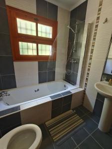a bathroom with a tub and a toilet and a sink at Casa Mimosa, Calonge Cabanyes in Calonge +10 photos