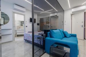 a living room with a blue couch and a bed at La Suite Nel Borgo - Ai Piedi delle Alpi&Centro Storico in Borgo San Dalmazzo +9 photos