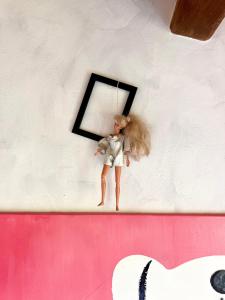 a doll hanging on a wall with a black frame at La Rock House BnB in Mercato Saraceno