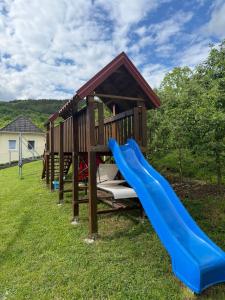 a playground with a slide in the grass at Apartman za odmor Plivska Jezera in Jajce