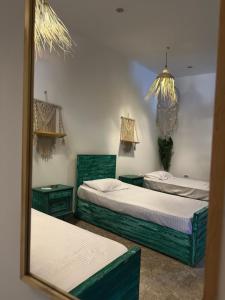 two beds in a room with a mirror at Studio In DaHaB in Dahab +7 photos
