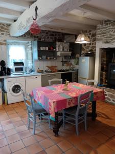 a kitchen with a table with a pink table cloth at La Chaumière en Bellevue in Muzillac
