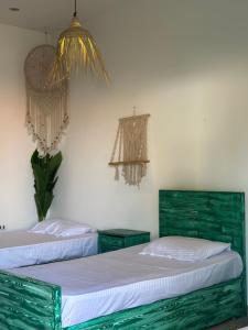 two beds with green headboards in a room at Studio In DaHaB in Dahab