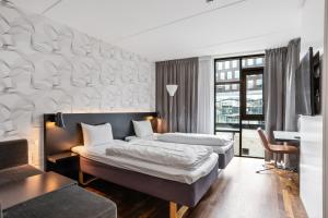 a hotel room with two beds and a desk at Comfort Hotel Union Brygge in Drammen