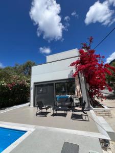 a patio with a table and chairs next to a pool at Villa Nicolas Plataria in Plataria