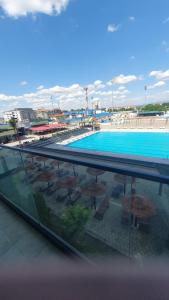 a swimming pool with tables and umbrellas on a building at Aqua Lux Apartman in Jagodina