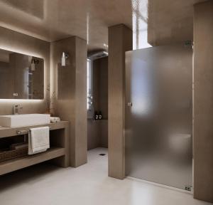 a bathroom with a shower and a sink and a mirror at Terracotta Sunset Suites in Oia +48 photos