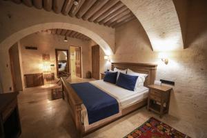 a bedroom with a bed in a room with an archway at Sinasos Evleri in Nevşehir