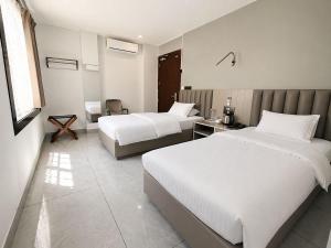 a hotel room with two beds and a desk at Kripalu Care Foundation in Vrindāvan