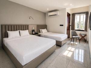 a bedroom with two beds and a desk and a chair at Kripalu Care Foundation in Vrindāvan