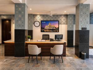 an office with a desk with two chairs and a clock at Kripalu Care Foundation in Vrindāvan
