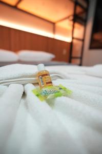 Eine Flasche Sonnencreme steht auf einem Bett. in der Unterkunft Hotel Pandolfi in Dois Vizinhos