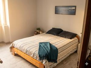 a bedroom with a bed with a green blanket on it at Volca'séjour in Orcines
