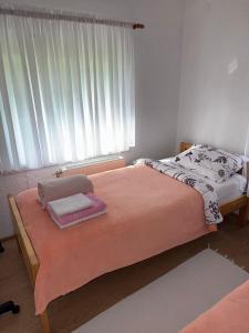 a bed in a room with a large window at Apartman za odmor Plivska Jezera in Jajce