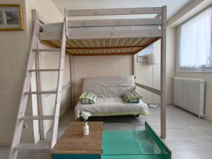 a bedroom with a bunk bed and a table at Studio cosy proche plage & centre in Le Havre +14 photos