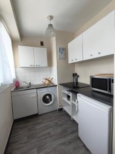 a kitchen with white cabinets and a washing machine at Studio cosy proche plage & centre in Le Havre