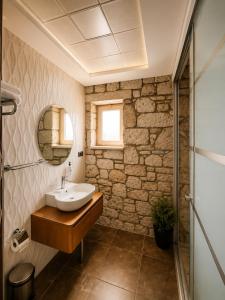 a bathroom with a sink and a stone wall at F&G Alaçatı in Alaçatı +15 photos