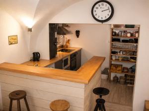 a kitchen with a counter and a clock on the wall at Volca'séjour in Orcines