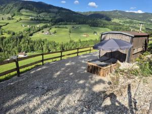 a bench with an umbrella sitting on top of a hill at Sommerkino in Krispl