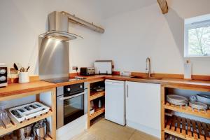 a kitchen with white cabinets and a counter top at The Suites at Pannells Ash in Castle Hedingham