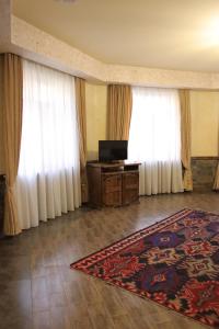 a living room with white curtains and a rug at Senger Qala Riverside in Qax