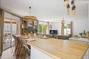 a kitchen and living room with a table and chairs at Villa typique - piscine et terrasse in La Teste-de-Buch