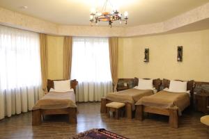 a hospital room with four beds and a chandelier at Senger Qala Riverside in Qax