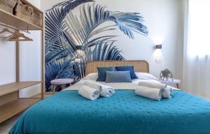 a bedroom with a large blue bed with a palm tree mural at NURAS - Affittacamere L'Azzurra - Double bedrooms private bathroom and seaview solarium in Sorso