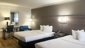 a hotel room with two beds and a desk at Motel 6 Aurora, CO - Medical Center in Aurora