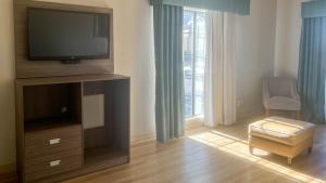 a living room with a flat screen tv and a chair at Motel 6 Aurora, CO - Medical Center in Aurora