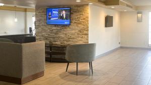 a waiting room with a tv on a brick wall at Motel 6 Aurora, CO - Medical Center in Aurora +16 photos