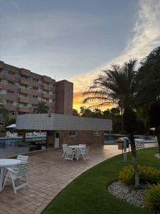 a patio with white tables and chairs and a building at Gran Lençóis in Barreirinhas