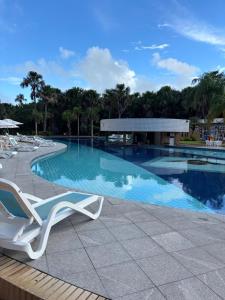 a swimming pool with a white lounge chair next to it at Gran Lençóis in Barreirinhas