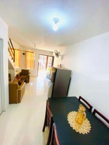 a kitchen and living room with a table and a refrigerator at Sparrow Transient Townhouse in Davao City