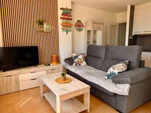 a living room with a couch and a tv at Roses Beach in Roses