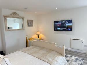 a bedroom with a bed and a tv on the wall at Altons Bothy Guest House in Kinmuck